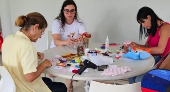 Mães e voluntária fazendo artesanato
